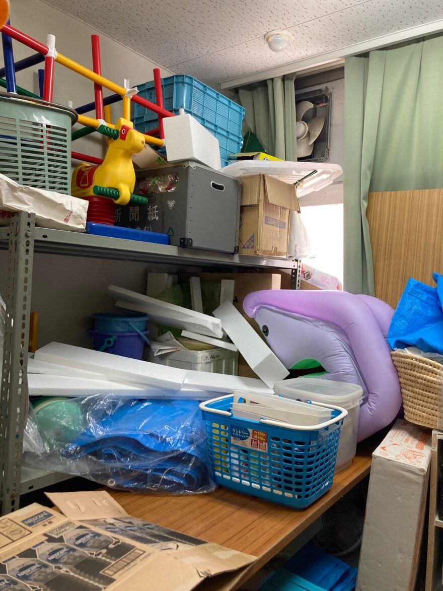 ビニールシートや発泡スチロールなど、使用目的が異なるモノが混在した棚。空間が有効活用されていない状態。

