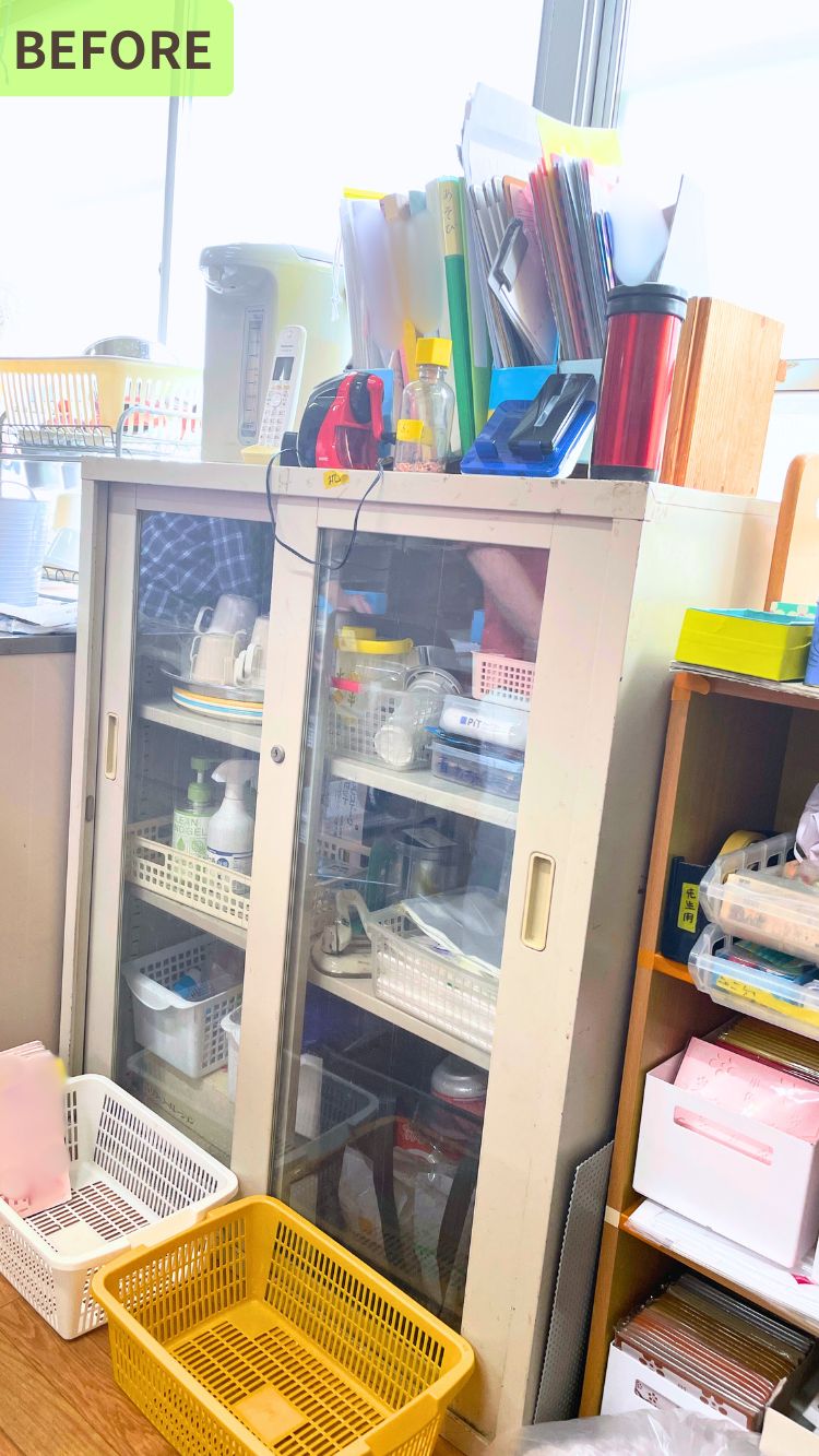 棚の中がファイルやかご、箱などで詰め込まれており、整理されていない状態の写真。棚には文房具や書類、日用品が混在して収納されている。