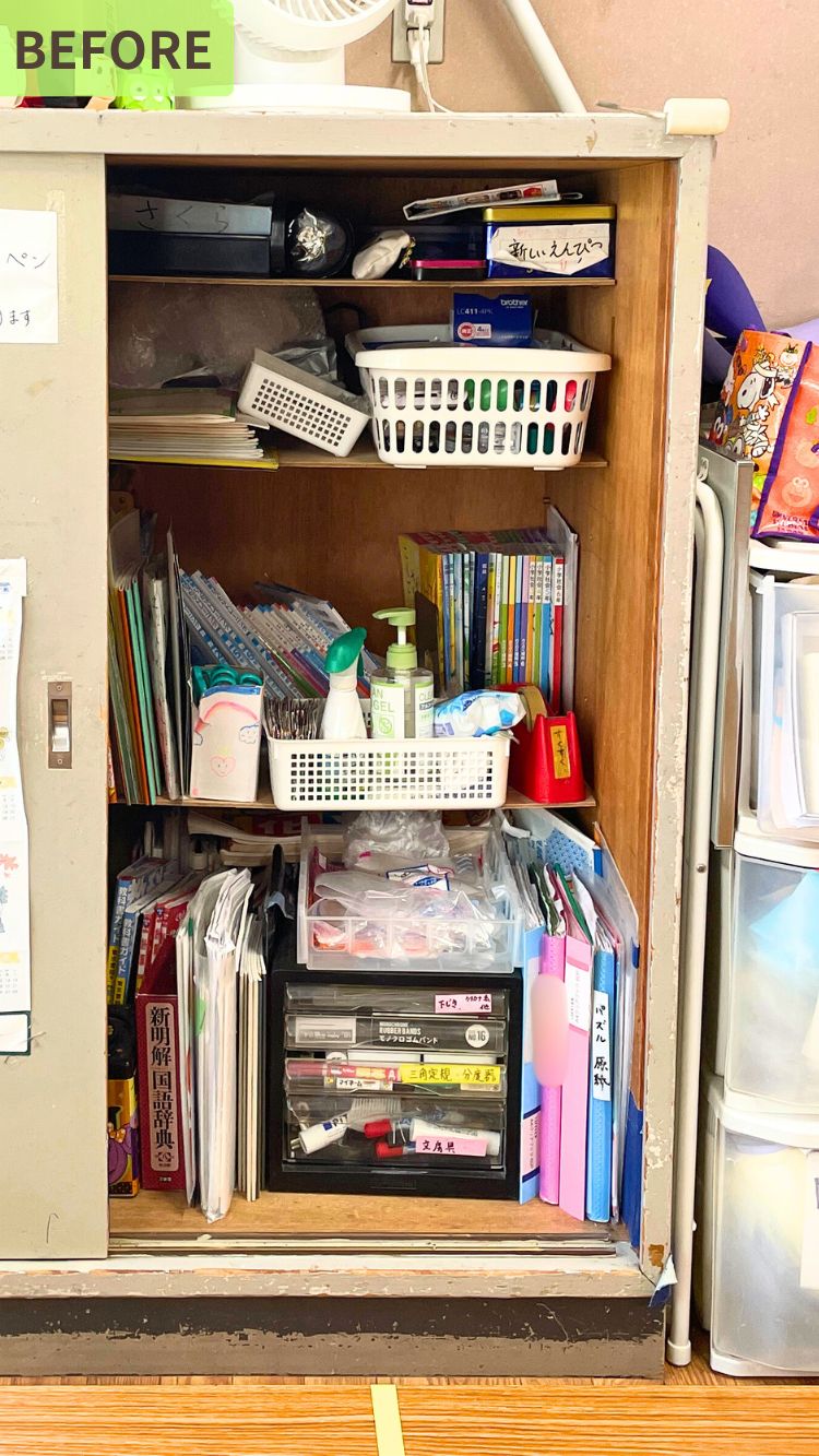 文房具、書類、衛生用品などが詰め込まれたキャビネット。棚の上には扇風機が置かれている。