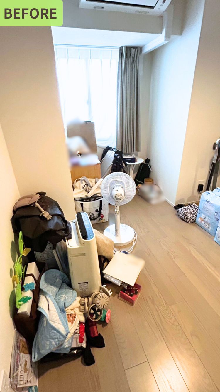 前の整理洋室の様子。扇風機や加湿器、バッグ、雑貨などが床に置かれており、スペースが雑多に見える状態。