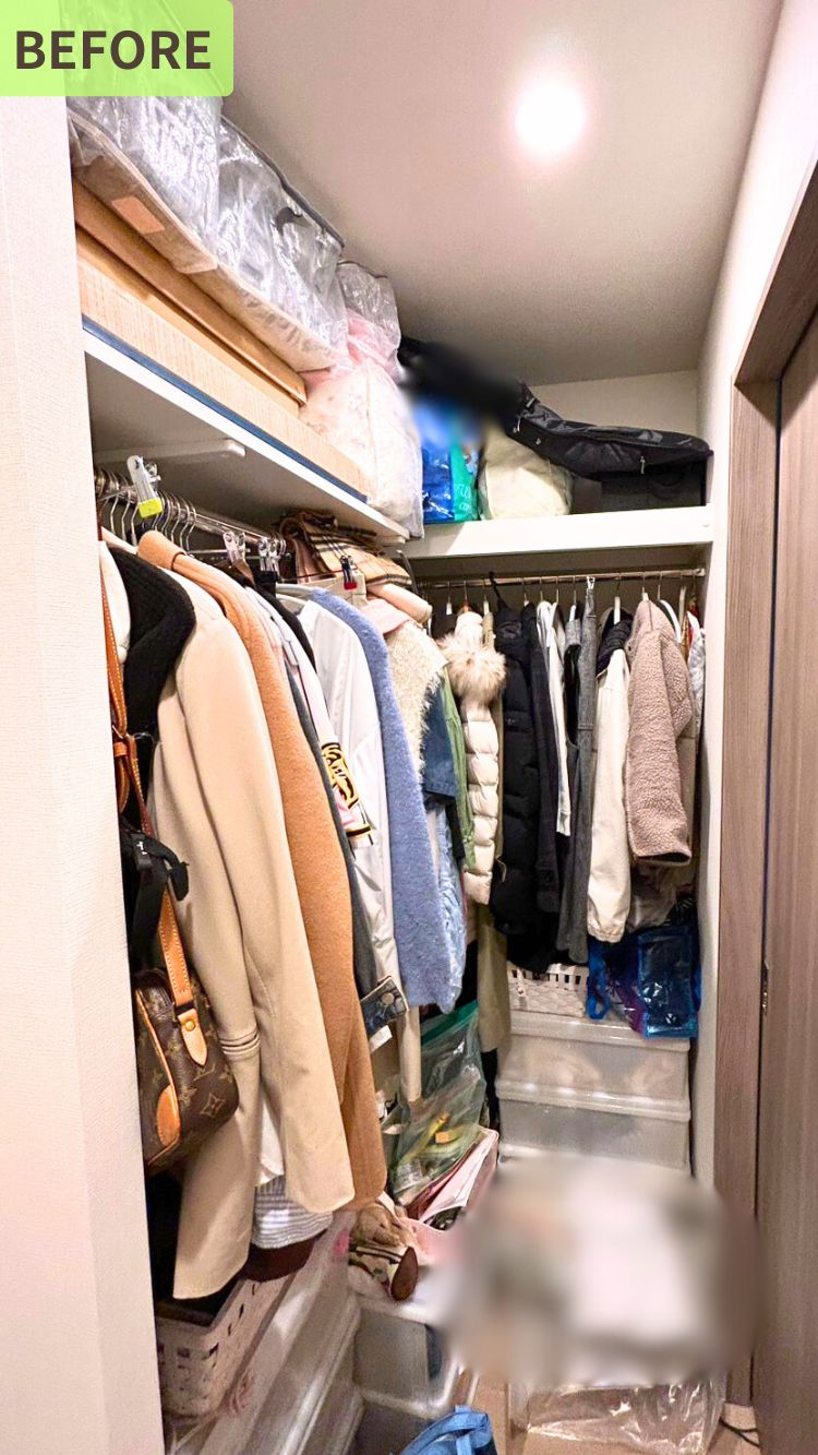 子育て中のご家庭のマンションにある収納クローゼットのビフォー写真。 ハンガーに衣類がびっしりとかかっており、棚の上や足元にも荷物やケースが積まれており、全体的に物が多く雑然としている様子が写っている。